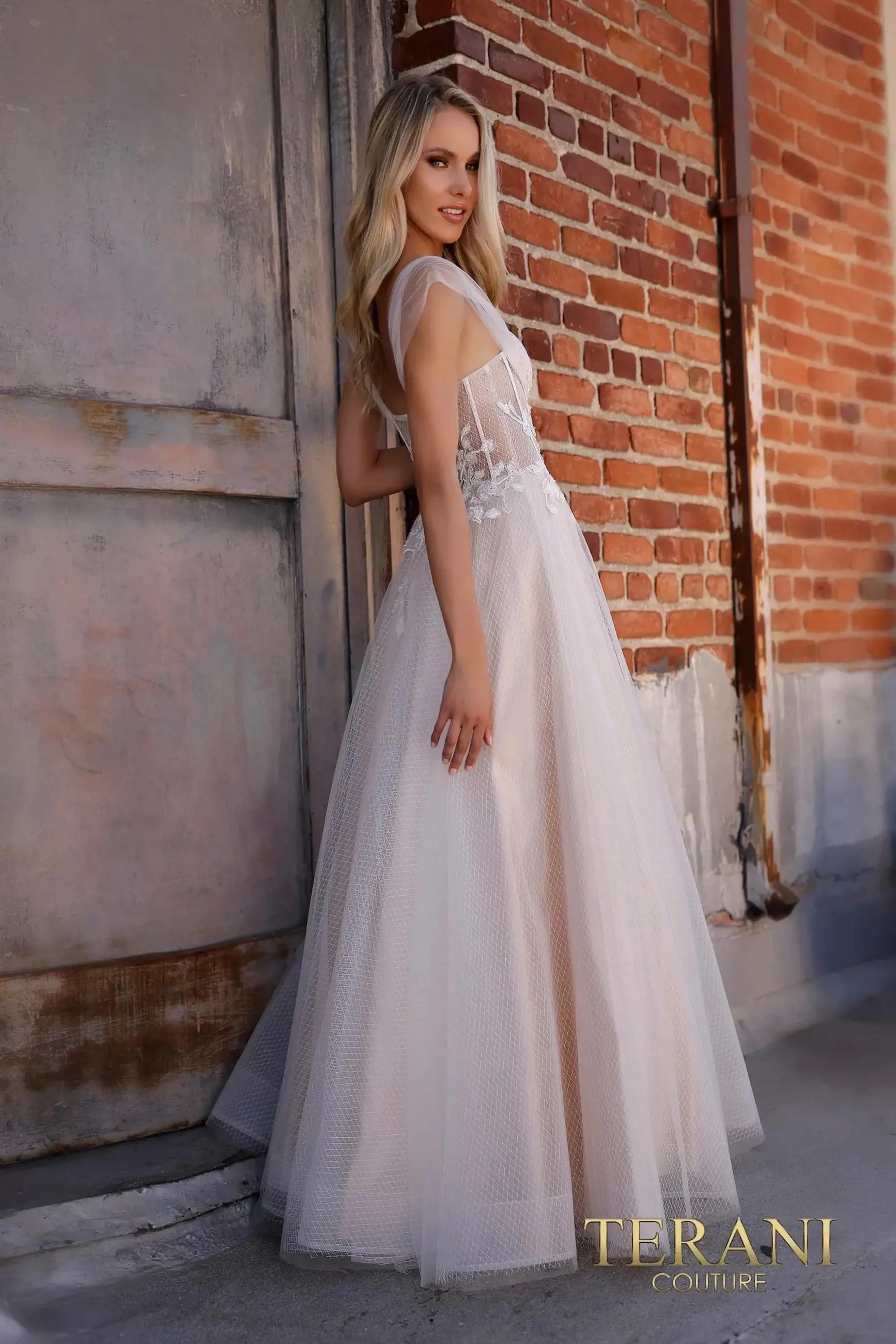 Model in tulle dress next to brick wall